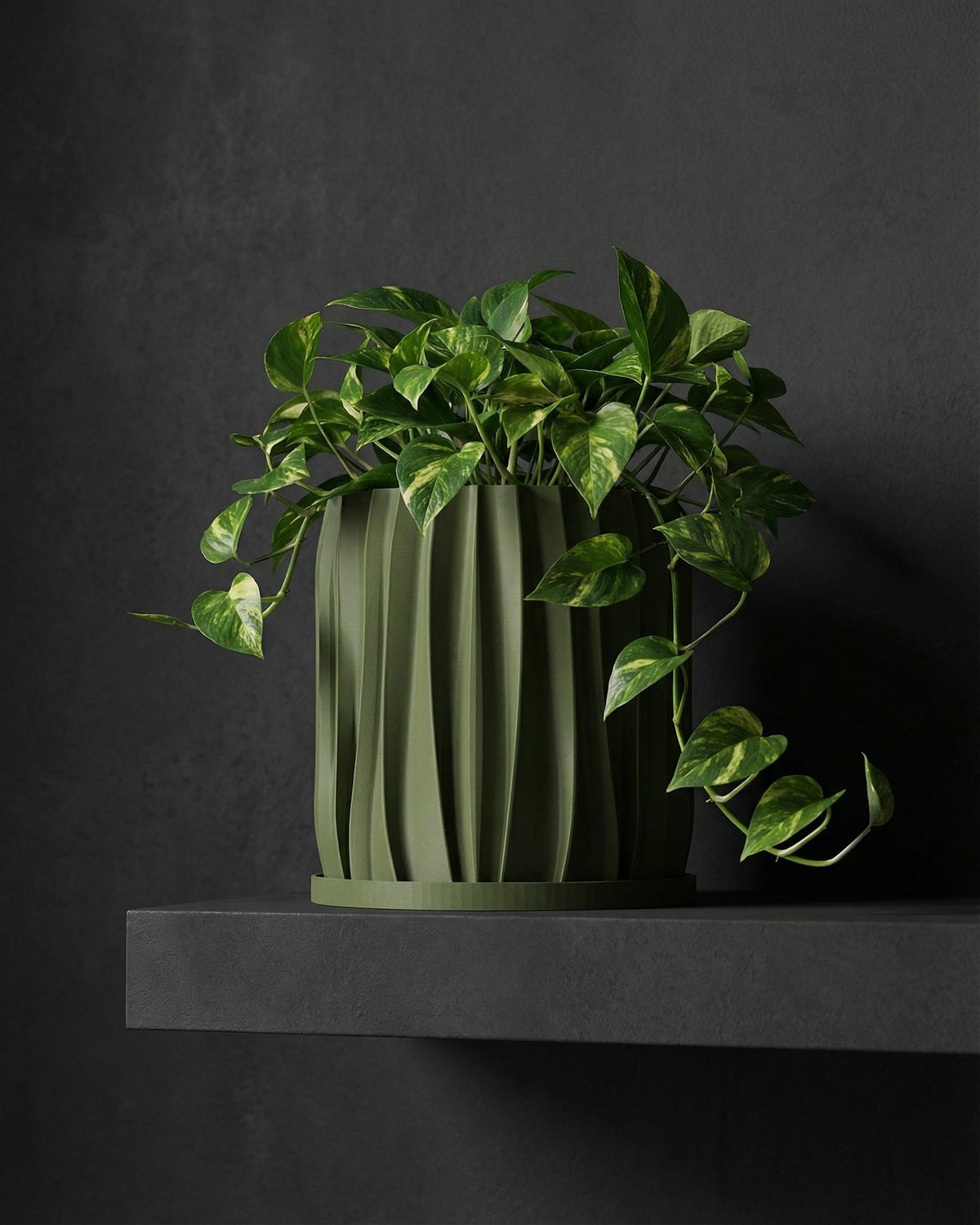 A green planter pot with a plant sits on a wooden table in a room with a rug and a basket hanging on the wall.