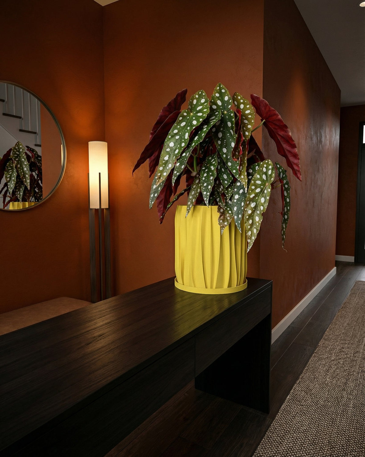 A bright yellow planter pot with a green plant sits on a white windowsill next to a window with sheer white curtains.