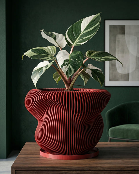 A red, round, slatted planter pot filled with a lush green ivy plant sits on a dark wood shelf next to books and a gold sculpture.