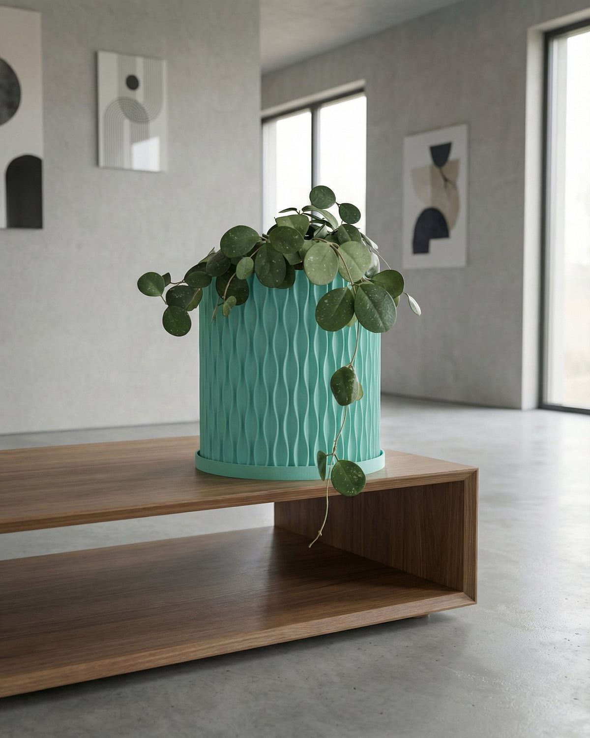 A light blue planter with a plant sits on a wooden windowsill in front of a window.