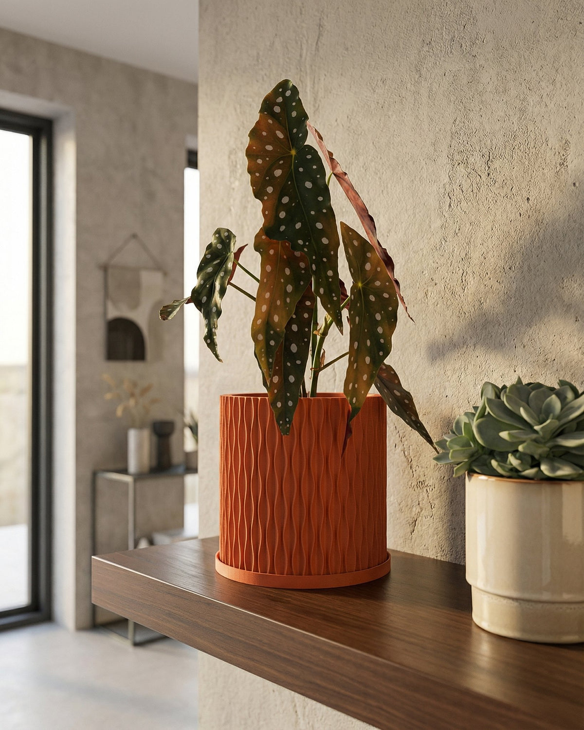 A fiddle leaf fig plant in a textured orange planter pot sits on a wooden table against a green wall.