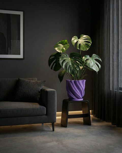 A purple planter pot with a plant on a wooden table. The pot has a textured design.