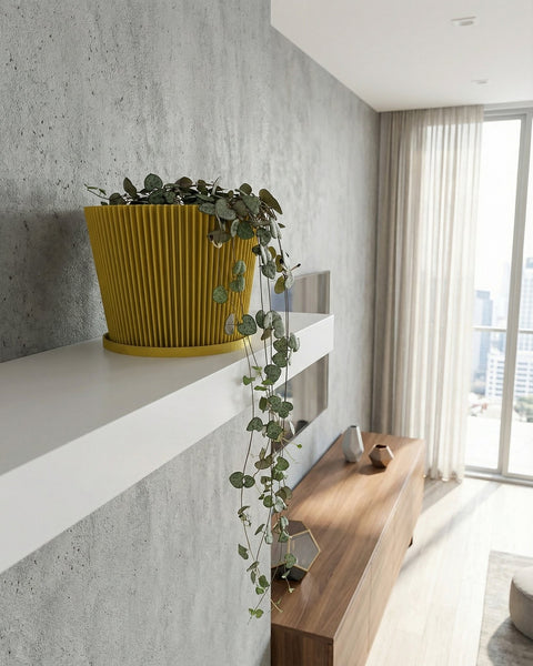 A vibrant yellow planter pot with a geometric pattern holds a lush green palm plant in a well-lit room.