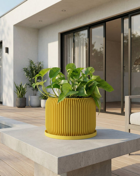 A yellow planter pot with a green plant on a wooden cabinet against a blue wall with a round mirror.