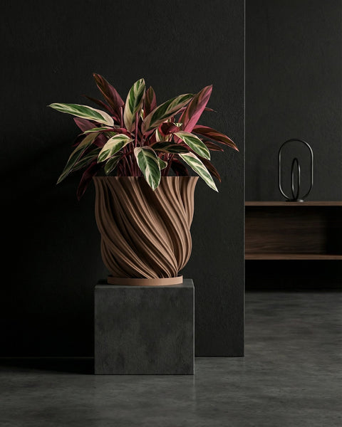 A Monstera plant sits in a brown, textured planter pot on a light wooden windowsill. The plant has green and white variegated leaves.