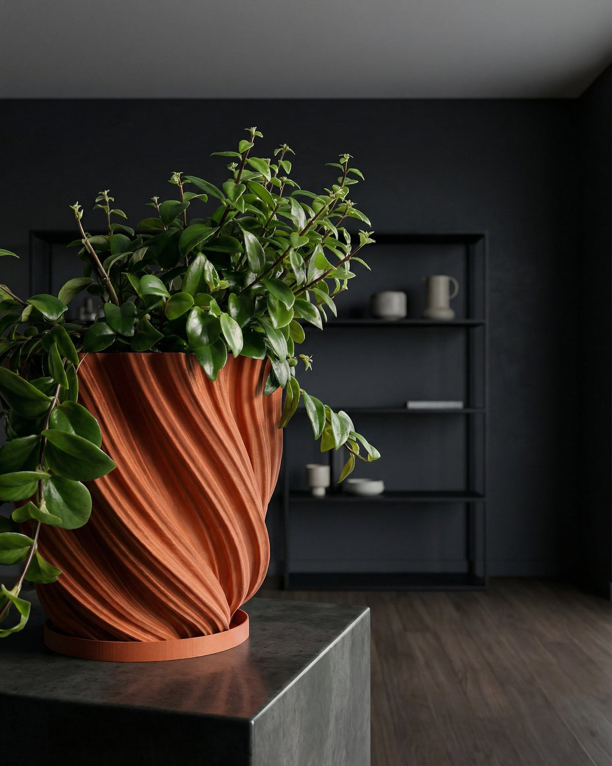 A fiddle leaf fig plant in a textured orange planter pot sits on a wooden table against a green wall.