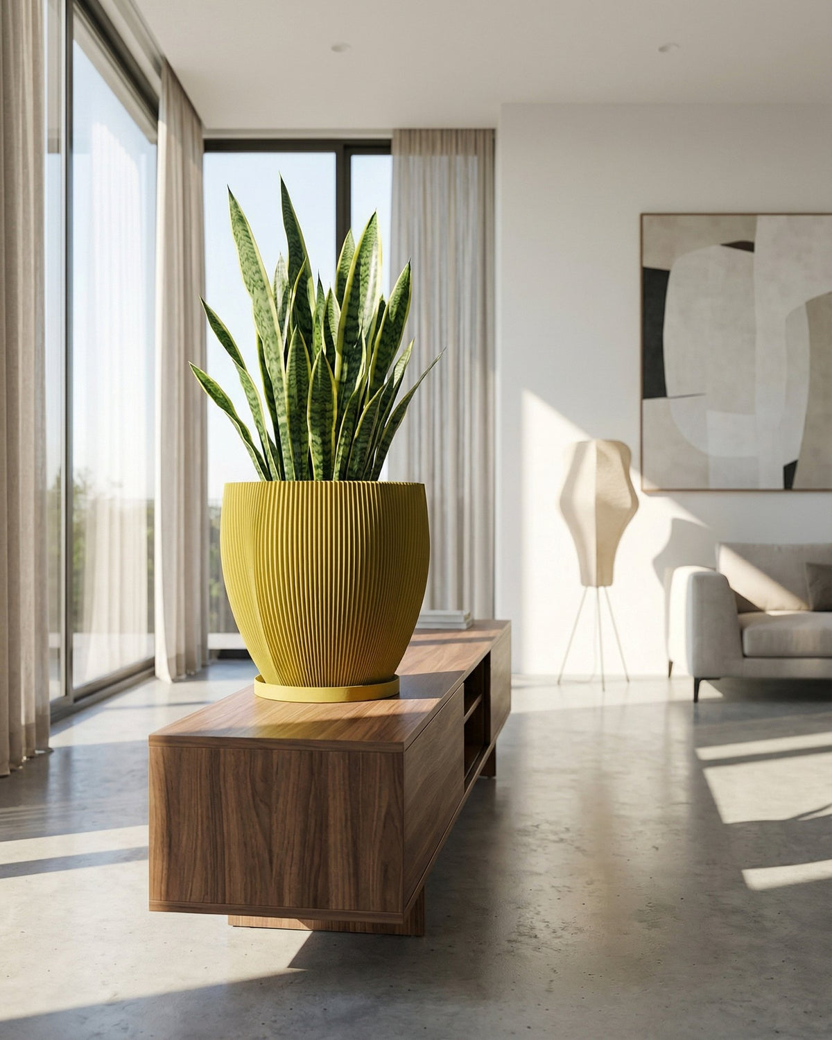 A yellow planter pot with a green and pink plant sits on a dark wood table in a room with olive green walls.