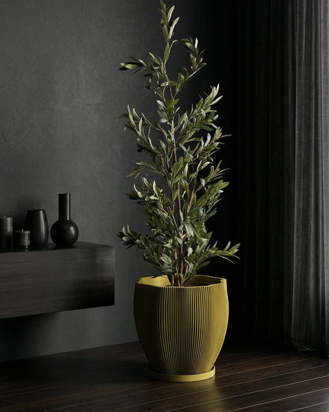 A yellow planter pot with a green plant sits on a windowsill, bathed in sunlight. The pot has a textured, swirling design.