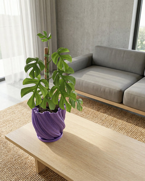 A purple planter pot with a green plant inside sitting on a window sill.