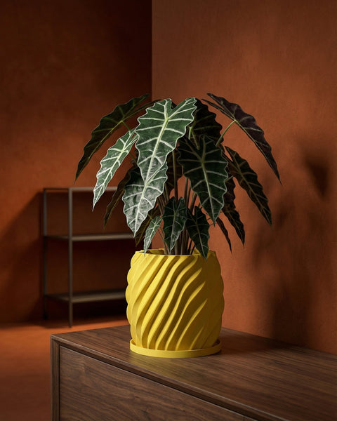 A yellow planter pot with a plant on top of a wooden cabinet. The pot has a wavy design.