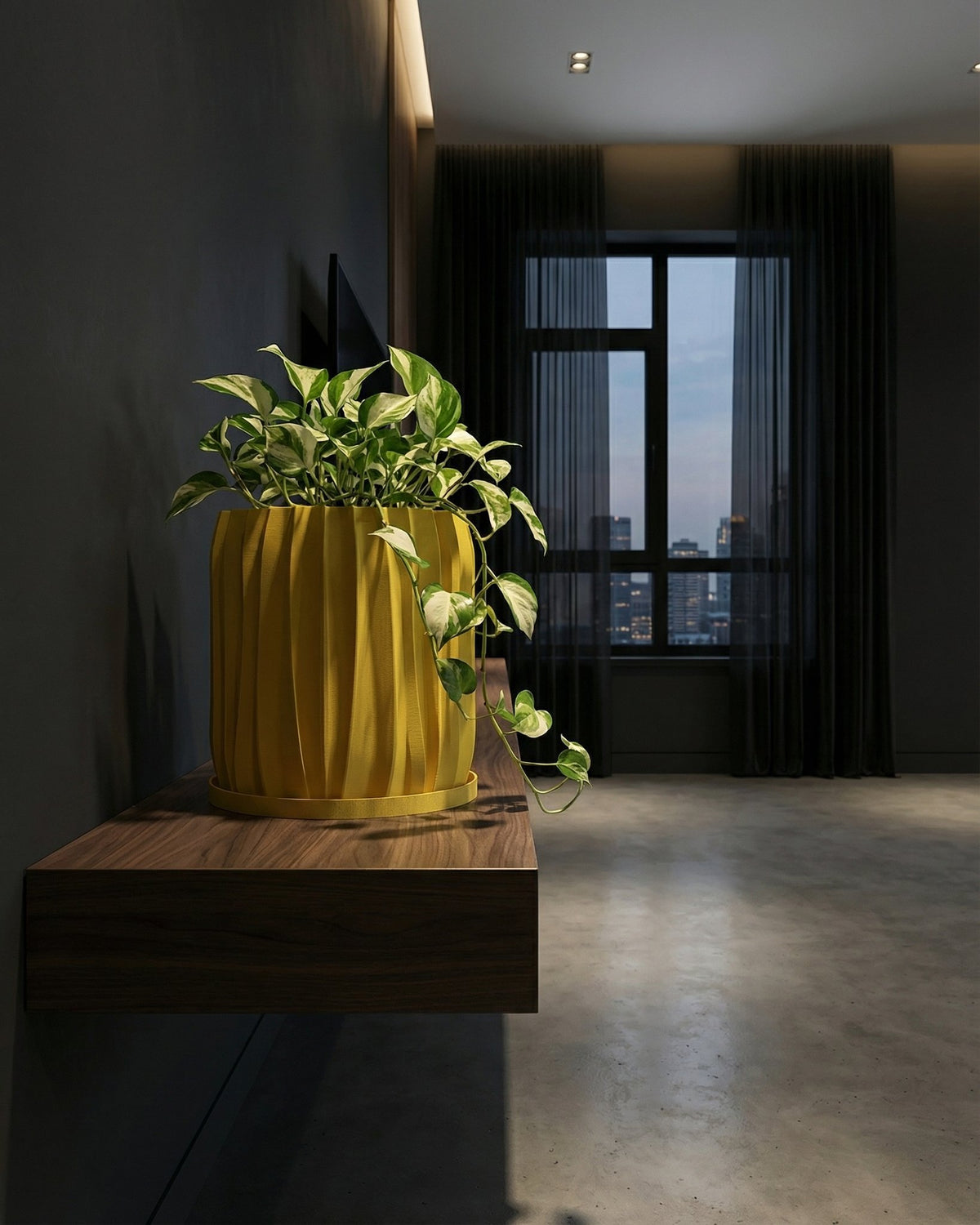 A vibrant yellow planter pot with a lush green plant sits atop a dark gray surface, adding a pop of color to the modern interior.