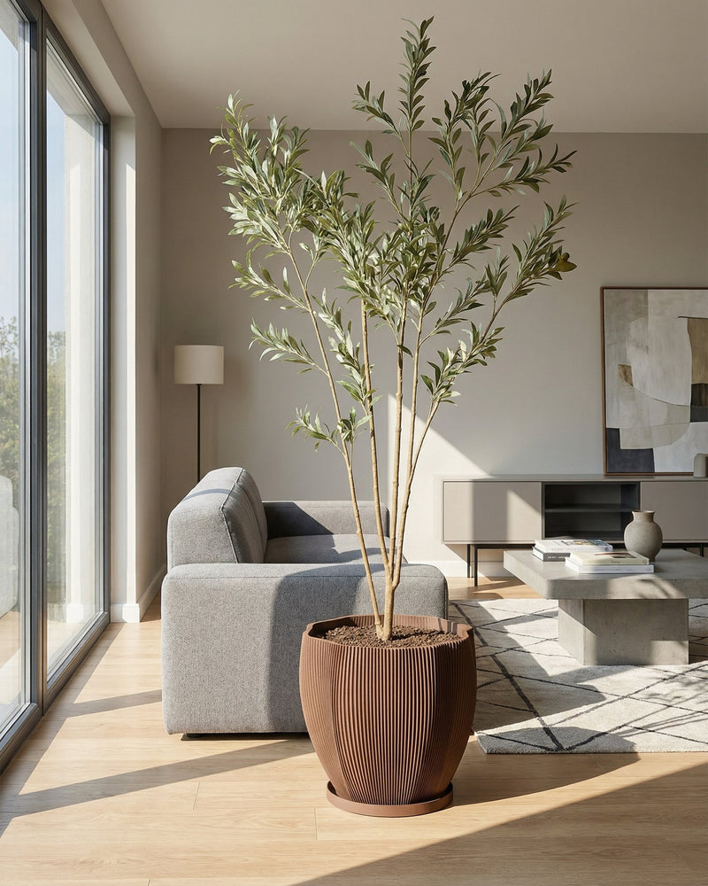 A variegated plant in a brown textured planter pot sits on a wooden cabinet against a mustard-colored wall.