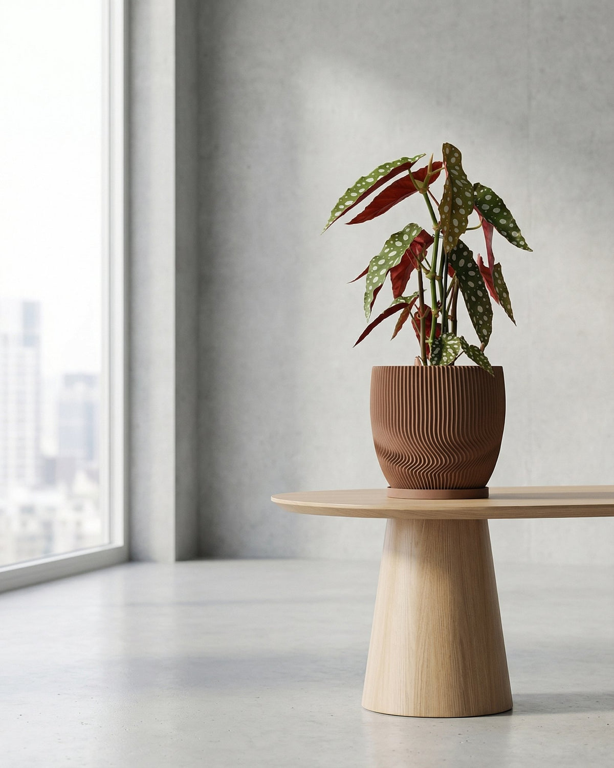 A brown planter pot with a plant on a wooden table in a room with a large window. The planter pot has a unique, textured design.