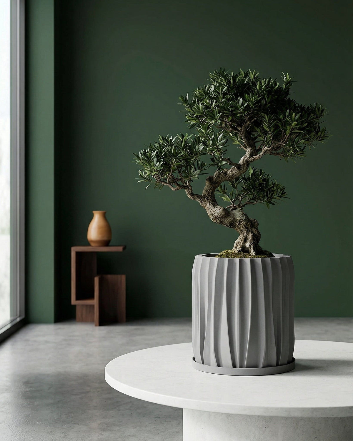 A Monstera plant in a textured gray planter pot sits on a white windowsill, bathed in sunlight.