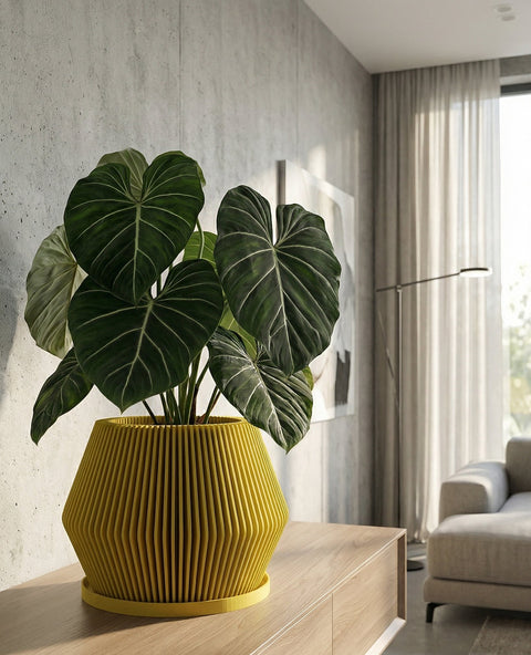 A close-up shot showcases a vibrant yellow planter pot with a unique ribbed texture, holding a lush green Pilea peperomioides, commonly known as the Chinese money plant. The pot sits atop a sleek, wooden dresser, with a modern art piece and decorative object subtly placed in the background. The scene is bathed in soft, natural light, highlighting the plant's glossy leaves and the pot's distinctive design.
