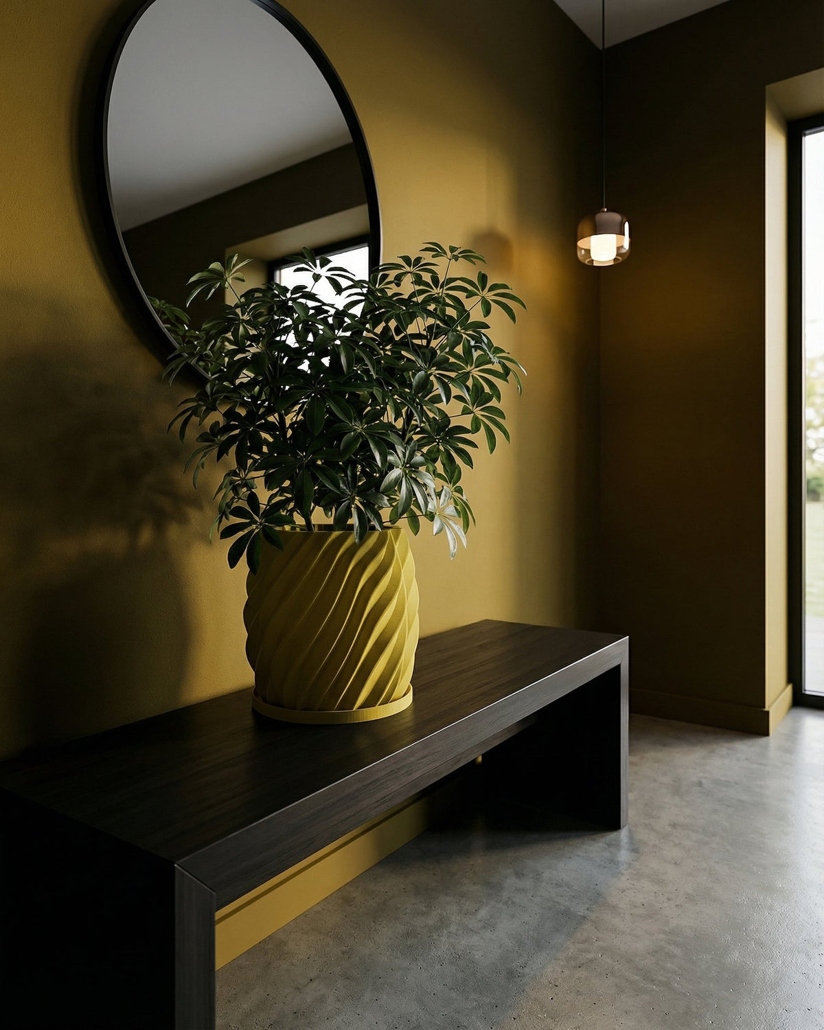 A green plant in a yellow, swirled planter pot sits on a dark wood table against a yellow wall with a round mirror.