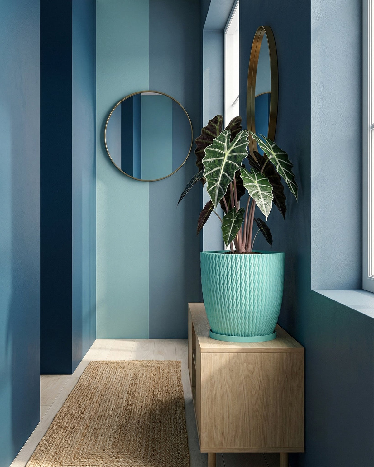 A turquoise planter pot with a plant sits on a wooden cabinet in a blue-themed room with a round mirror.
