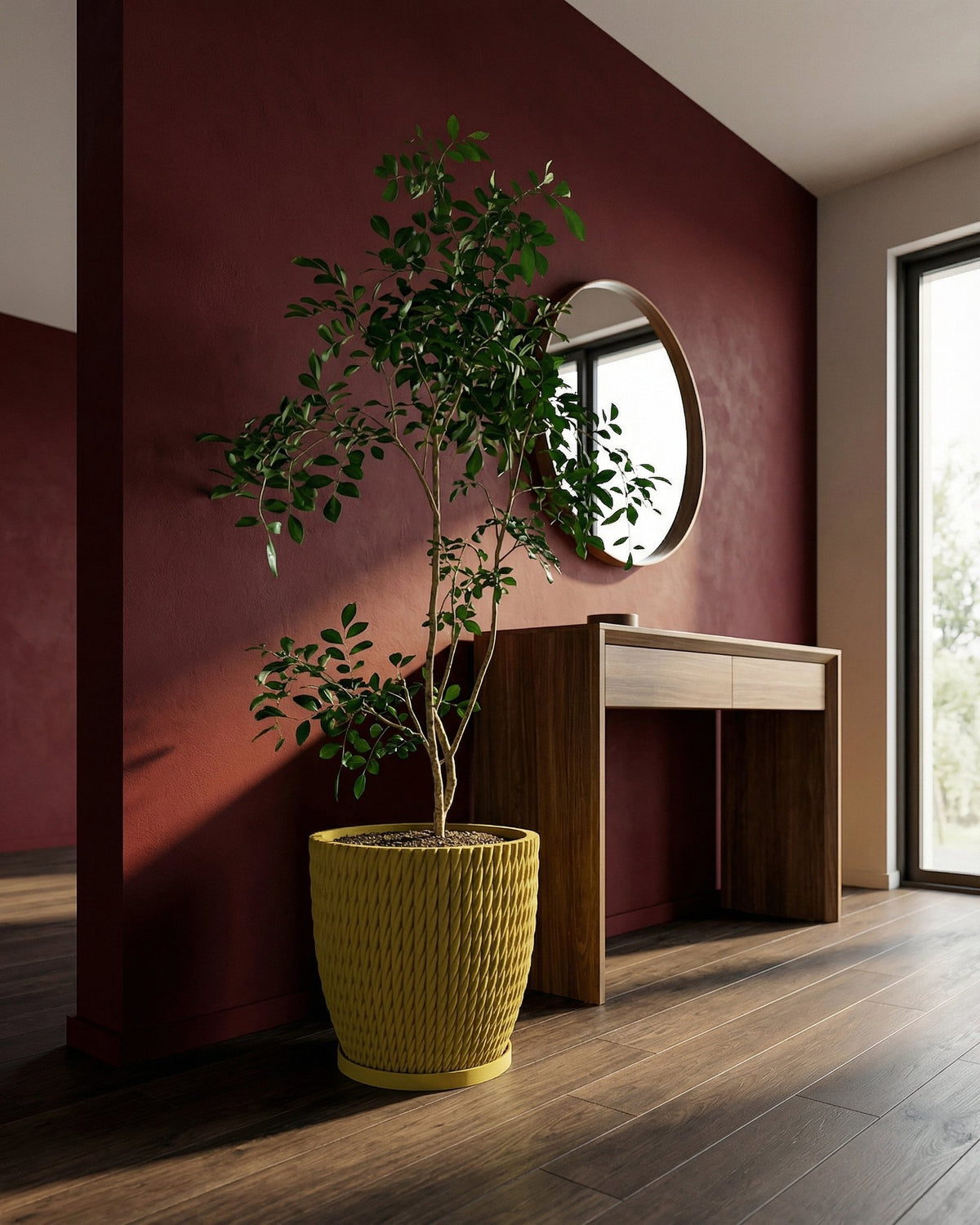A yellow planter pot with a green plant inside is on a wooden floor in front of a red wall.