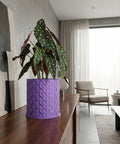 A purple planter pot with a green plant sits on a shelf in a dimly lit room.