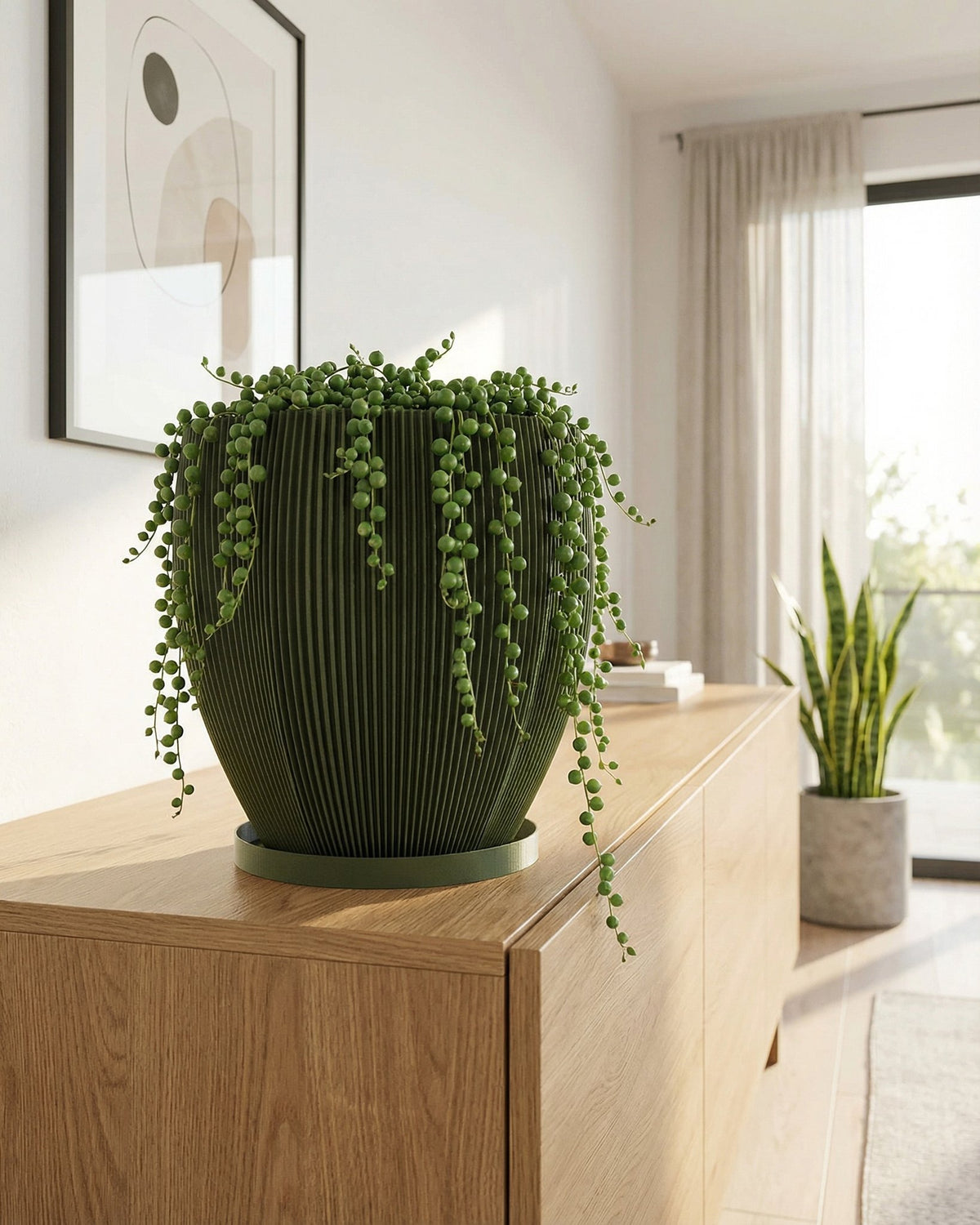 A green planter pot with a plant sits on a wooden table in a room with a rug and a basket hanging on the wall.