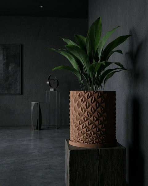 A brown geometric planter pot with a green plant sits on a wooden block in a dark room.