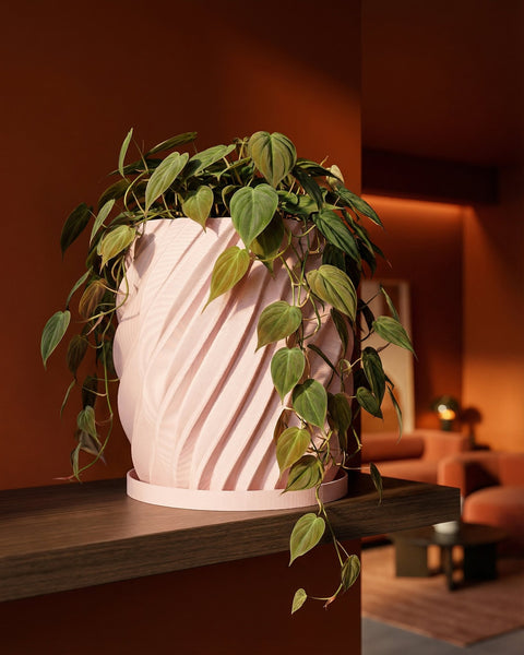 A pink planter pot with a green plant on a dark wooden shelf. The pot has a unique, textured design.