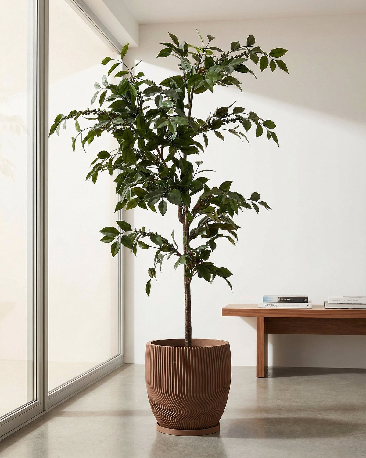 A brown planter pot with a tree in it. The pot has a unique, wavy design.
