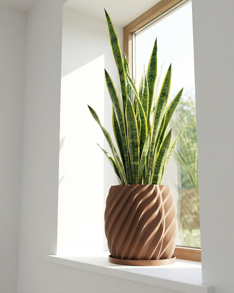A snake plant in a brown, swirled planter pot sits on a white windowsill in front of a window.