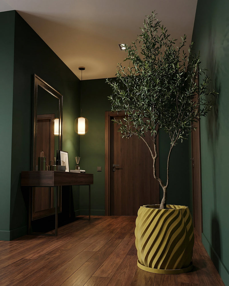 A green room with a wooden floor features a large potted plant in a unique, textured yellow planter pot.