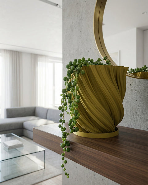 A yellow textured planter pot with a plant next to a gray couch and a round rug in a room with dark green walls.