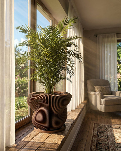A Monstera plant in a brown, ribbed planter pot sits on a wooden windowsill, bathed in natural light. The pot is the focal point.