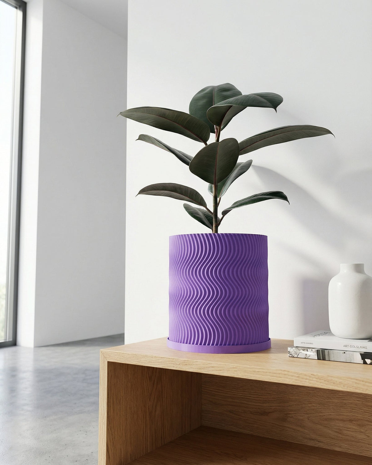 A purple planter pot with a plant sits on a wooden table next to a white vase and books.