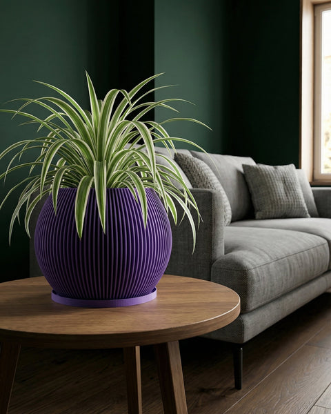 A purple planter pot with a spider plant sits on a wooden table in front of a gray couch and a dark green wall.