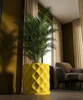 A vibrant yellow planter pot with a geometric pattern holds a lush green palm plant in a well-lit room.